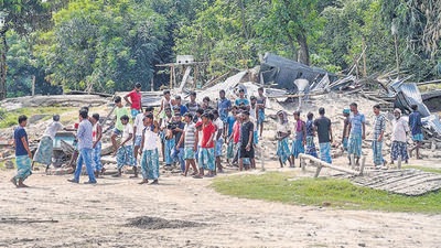 Villagers near their houses which were demolished during an eviction drive, at Gorukhuti in Darrang district, on Friday. The Assam government on Friday ordered a judicial probe into the violence. (PTI)