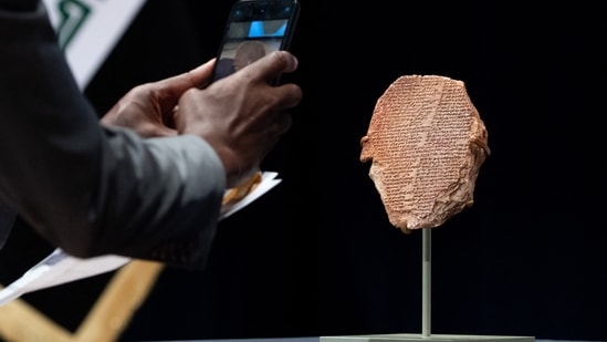 A man photographs the Gilgamesh Tablet, a 3,500-year-old Mesopotamian cuneiform clay tablet that was believed to be looted from Iraq around 1991 and illegally imported into the US to be displayed at the Washington Museum of the Bible, during a ceremony to repatriate the tablet to Iraq, at the Smithsonian National Museum of the American Indian, in Washington, DC,(Photo by SAUL LOEB / AFP) A man photographs the Gilgamesh Tablet, a 3,500-year-old Mesopotamian cuneiform clay tablet that was believed to be looted from Iraq around 1991 and illegally imported into the US to be displayed at the Washington Museum of the Bible, during a ceremony to repatriate the tablet to Iraq, at the Smithsonian National Museum of the American Indian, in Washington, DC,(Photo by SAUL LOEB / AFP)