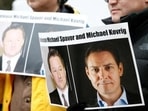 People hold signs calling for China to release Canadian detainees Michael Spavor and Michael Kovrig.