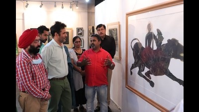 Visitors checking out a painting during the exhibition at Government College of Art in Chandigarh. (HT photo)