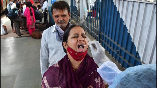 A medic collects swab samples for Covid-19 test of passengers arriving on outstation trains at Dadar station, in Mumbai. The Maharashtra government will finalise and issue standard operating procedure (SOP) early next week for the management of the cinema halls and auditoriums to follow, senior officials said (HT PHOTO)