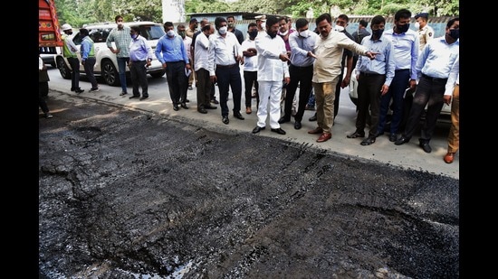 Thane Guardian Minister, Eknath Shinde (centre) during a survey of Thane roads filled with potholes on Friday. He gave directives to TMC to take action against concerned officials for poor road conditions. (PRAFUL GANGURDE/HT PHOTO)