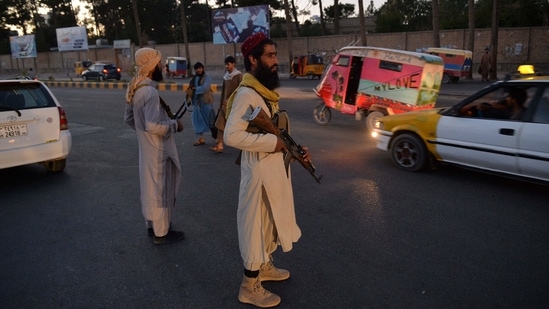Taliban fighters stand guard along a road in Herat on September 21, 2021.(AFP)