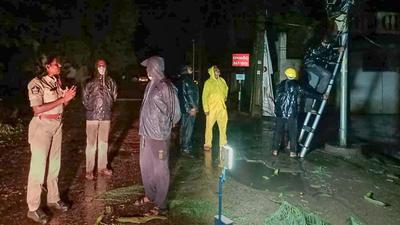 Police personnel and locals at a site after a tree fell due to heavy winds induced by Cyclone Gulab in Srikakulam district on Sunday. (PTI PHOTO.) Police personnel and locals at a site after a tree fell due to heavy winds induced by Cyclone Gulab in Srikakulam district on Sunday. (PTI PHOTO.)