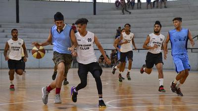 Players in action during the district basketball championship at Guru Nanak Stadium in Ludhiana on Sunday. (Harsimar Pal Singh/HT)