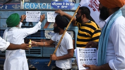 Farmers paste a sign on a bus in support of the September 27 Bharat Bandh. (AFP) Farmers paste a sign on a bus in support of the September 27 Bharat Bandh. (AFP)