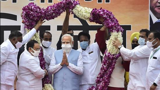 Prime Minister Narendra Modi being garlanded by BJP national president JP Nadda and party members on his arrival at AFS Palam in New Delhi on Sunday. (PTI)