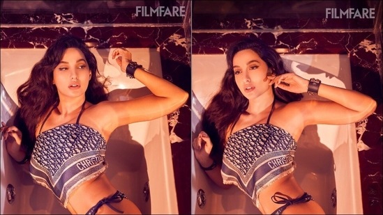 Flaunting an hourglass figure, Bollywood actor Nora Fatehi grabbed eyeballs for her jaw-dropping look as she slipped into a blue and white bikini from Dior and oozed oomph in a steamy photoshoot for Filmfare magazine.(Instagram/norafatehi)