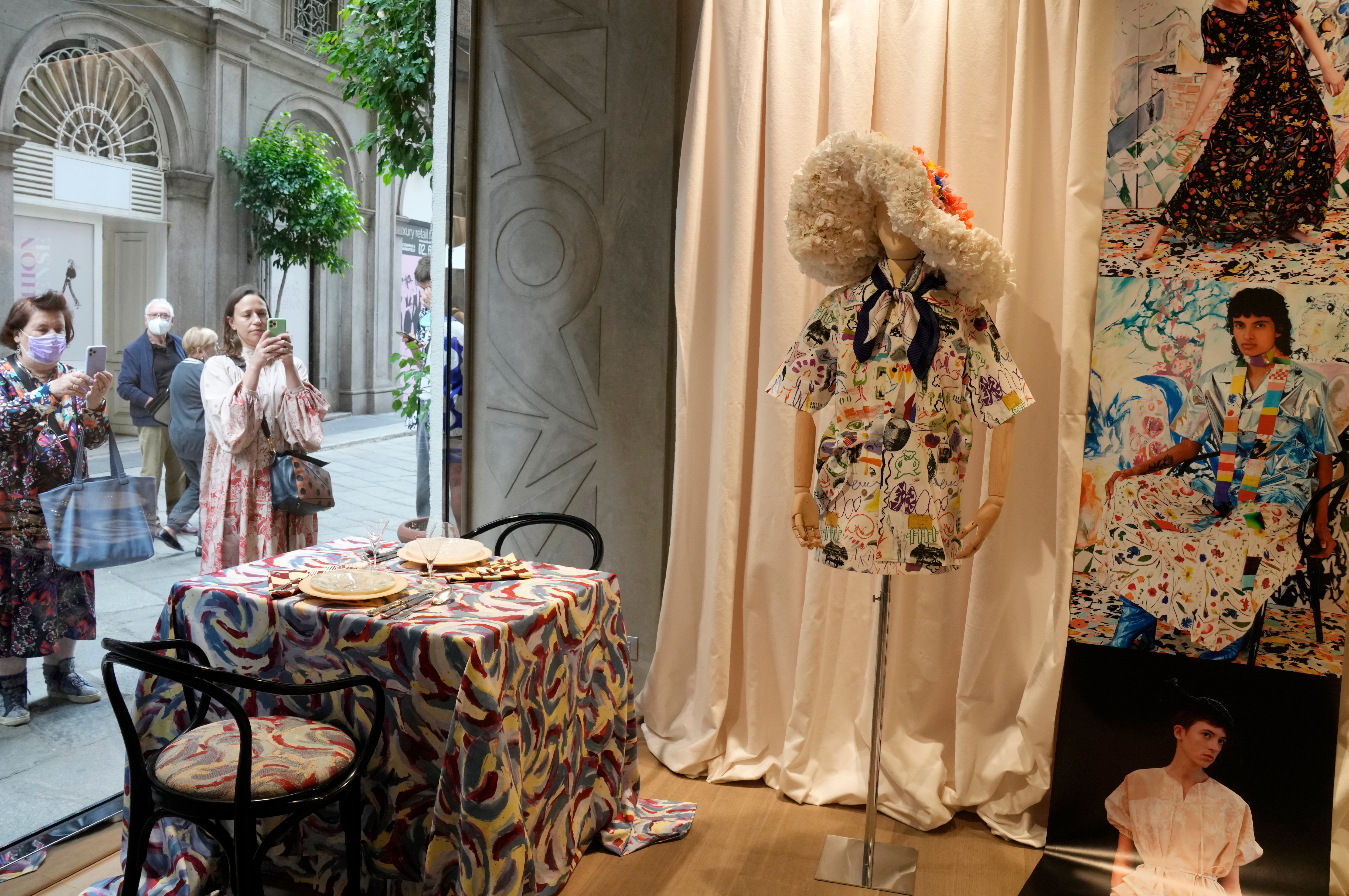 People take pictures of the shop window displaying creations as part of the Arthur Arbesser women's Spring Summer 2022 collection(AP)