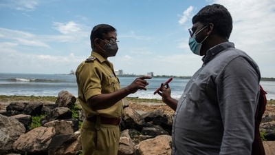A man shows his Covid19 vaccination certificate to a police officer in Fort Kochi, Kerala (AP) A man shows his Covid19 vaccination certificate to a police officer in Fort Kochi, Kerala (AP)