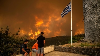 Local residents look at the wildfire approaching the village of Gouves on Evia (Euboea) island, the second largest Greek island on August 8. (Picutre for representation only) (AFP) Local residents look at the wildfire approaching the village of Gouves on Evia (Euboea) island, the second largest Greek island on August 8. (Picutre for representation only) (AFP)