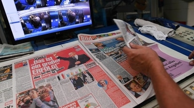 A worker checks a printed edition of Bild newspaper that shows candidate for chancellor Olaf Scholz, of Social Democratic Party (SPD), after the first exit polls for the general elections in Berlin, Germany. (Reuters Photo) A worker checks a printed edition of Bild newspaper that shows candidate for chancellor Olaf Scholz, of Social Democratic Party (SPD), after the first exit polls for the general elections in Berlin, Germany. (Reuters Photo)