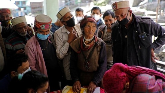Villagers queue to get the dose of Covishield vaccine, near Malana village in Himachal Pradesh, on September 14. When Gupta's team reached the village nearly three dozen people, who took their first shots before the invocation, lined up to get their second shots just opposite an ancient temple to the deity.(Adnan Abidi / REUTERS)