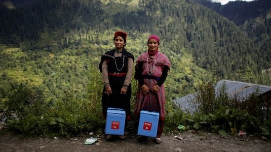 Nirma Devi, 31, and Phula Devi, 30, hold boxes containing Covishield vaccines as they pose for a picture at Malana village in Himachal Pradesh, on September 14. India wants to vaccinate nearly all of its adults by December, having administered at least one dose to two-thirds of people and two doses in less than a quarter. Himachal Pradesh chief minister Jai Ram Thakur wants his state to be the fastest to reach the two-dose milestone, hopefully by November.(Adnan Abidi / REUTERS)