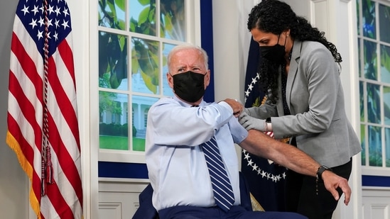 US President Joe Biden holds up his sleeve to receive his coronavirus disease (COVID-19) booster vaccination in the Eisenhower Executive Office Building's South Court Auditorium at the White House.(REUTERS)