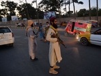 Taliban fighters stand guard along a road in Herat. Taliban fighters stand guard along a road in Herat.