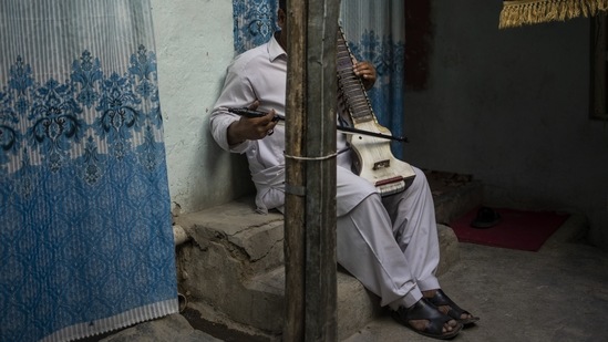 An Afghan musician poses for a portrait with his dilruba in Kabul, on September 18. Asked whether the Taliban government will ban music again, spokesman Bilal Karimi told The Associated Press, “Right now, it is under review and when a final decision is made, the Islamic Emirate will announce it.”(Bernat Armangue / AP)