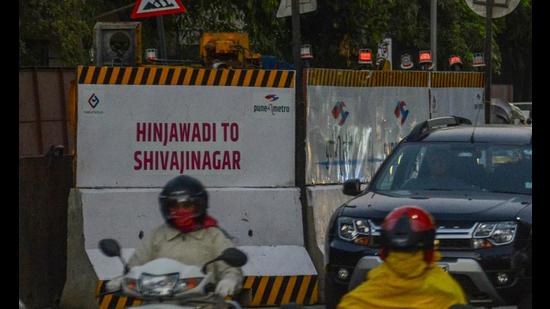 A board stating ongoing work of Shivajinagar to Hinjewadi metro in Pune. PMC tells PMRDA to lay cables for metro route after monsoons. (HT FILE)
