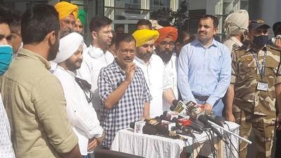 Delhi chief minister and Aam Aadmi Party national convener Arvind Kejriwal addressing the media at Chandigarh airport on Wednesday as Punjab AAP leaders look on. (HT Photo)
