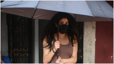 It is currently raining in Mumbai – Janhvi Kapoor was spotted by paparazzi carrying a huge black umbrella over her head. She left her tresses open. (HT Photos/Varinder Chawla)