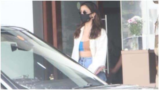 Flaunting her washboard abs, Alia chose a trendy dual-toned crop top with an oversized shirt and denim pants for her airport look. She nailed the classic chic and effortless combination for her flight into Mumbai, and we are taking styling cues from her.(HT Photo/Varinder Chawla)