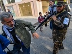 A member of the Taliban special forces pushes a journalist (L) covering a demonstration by women protestors outside a school in Kabul on September 30, 2021. (Photo by BULENT KILIC) A member of the Taliban special forces pushes a journalist (L) covering a demonstration by women protestors outside a school in Kabul on September 30, 2021. (Photo by BULENT KILIC)