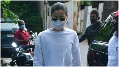 Alia completed her look of the day with classic white sneakers. She pulled her hair back into a clean bun and wore tinted shades. (HT Photos/Varinder Chawla)