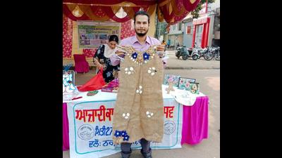 A man shows a dress made out of jute bag during Ludhiana MC’s waste-to-art exhibition. (HT PHOTO)