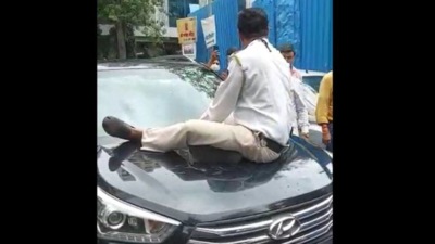 The driver did not stop and drove in spite of the constable sitting on its bonnet. (Twitter)