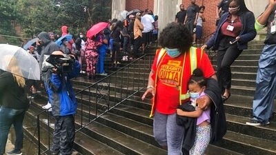 After the shooting, parents held umbrellas in a light drizzle and talked with each other as they waited for children to arrive at the church (AP) After the shooting, parents held umbrellas in a light drizzle and talked with each other as they waited for children to arrive at the church (AP)
