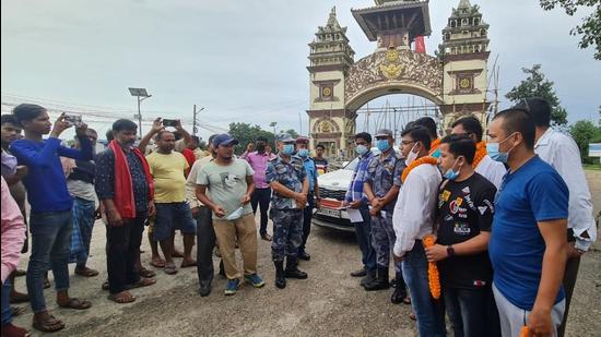 Nepalese authorities and security personnel welcome Indian visitors at Shankaracharya gate between Raxaul and Birgan after vehicular movement along the Indo-Nepal border resumed on Friday. (Santosh Kumar/HT PHOTO)