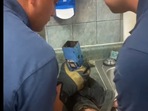 The image shows the firefighters looking inside the pipe.