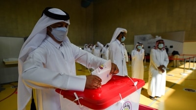 A Qatari man casts his vote as others wait in line during the Gulf Arab state's first legislative elections for two-thirds of the advisory Shura Council, in Doha, Qatar. (REUTERS)