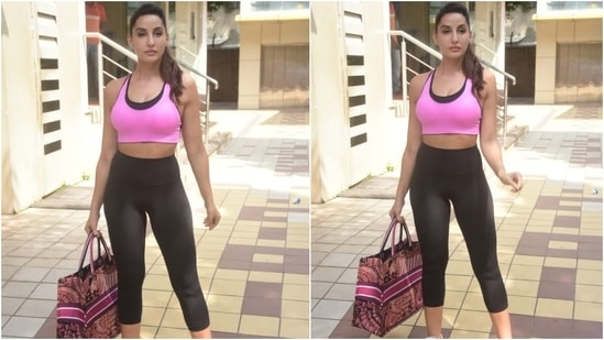 Nora was snapped outside her gym class today in Mumbai, and for the outing, she chose a note-worthy athleisure look - a hot pink sports bra teamed with a leggings set. The hot pink and black sports bra with a scooped neckline and broad straps spruced up her workout look.&nbsp;(HT Photo/Varinder Chawla)