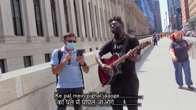 The image shows the US YouTuber and a man singing Kishore Kumar’s Hindi song.