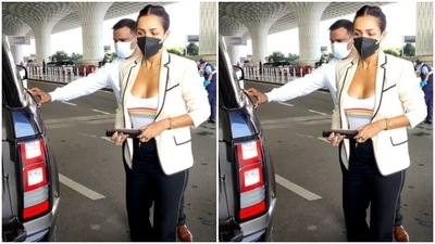 Malaika, in the later part of the day, was photographed flying out of the city. Her airport fashion is always on point – comfortable and travel-friendly. All masked up, she paired the white tank top and the black trousers with a swanky blazer. The white blazer had striped of black at the collars and it added more oomph to her look. (HT Photos/Varinder Chawla)