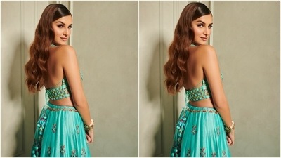 Tara's lehenga featured a backless bralette styled choli, an embroidered lehenga and a dupatta. The choli came with a halter plunging V neckline adorned with floral Resham embroidery in orange, yellow, red and green shades. The actor flaunted her toned midriff in the cropped blouse. (Instagram/@punitbalana)