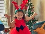 Inaaya Naumi Kemmu enjoying Christmas in her cute red dress and reindeer hairband.