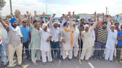 Farmers protesting delay in procurement in Karnal on Monday. They claim officials are citing higher moisture content in their produce for delay, even when they were ready to bear deductions. (HT Photo) Farmers protesting delay in procurement in Karnal on Monday. They claim officials are citing higher moisture content in their produce for delay, even when they were ready to bear deductions. (HT Photo)