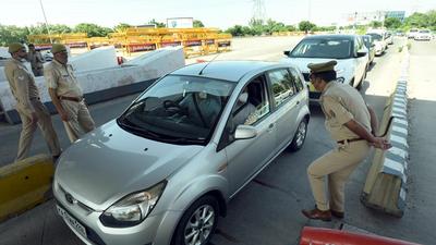 Police personnel screen vehicles on the DND Flyway, in Noida. (Sunil Ghosh/HT Photo)
