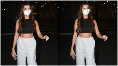 Tara Sutaria, freshly back from her London shoot to the city, was at her fashionable best. Tara chose a high-neck sleeve-less black cropped top and paired it with white joggers. The actor left her tresses open and looked absolutely stunning. (HT Photos/Varinder Chawla)