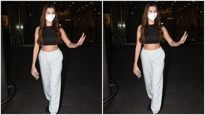 Tara opted for a pair of black sneakers to go with the outfit. All masked up, the actor waved for the cameras outside the airport. (HT Photos/Varinder Chawla)