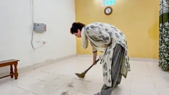 Congress General Secretary Priyanka Gandhi brooms the floor of a guest house where she is detained by police while on her way to visit violence-hit Lakhimpur Kheri.&nbsp;(PTI)