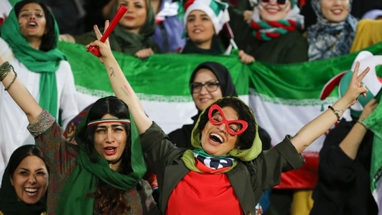 Iranian women cheer during the World Cup Qatar 2022 Group C qualification football match between Iran and Cambodia at the Azadi stadium in the capital Tehran in October 2019. (Photo by Atta Kenare/AFP) Iranian women cheer during the World Cup Qatar 2022 Group C qualification football match between Iran and Cambodia at the Azadi stadium in the capital Tehran in October 2019. (Photo by Atta Kenare/AFP)