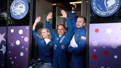 Russian cosmonaut Anton Shkaplerov, film director Klim Shipenko and actress Yulia Peresild wave as they leave to board the spacecraft. (via Reuters)
