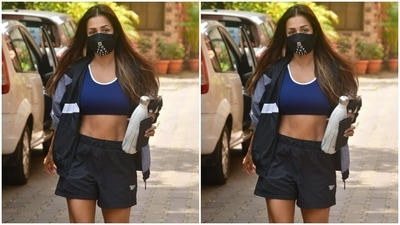 Malaika Arora is a joy to behold with every public appearance she makes. On Tuesday, the paparazzi spotted her on her way out of the yoga studio and she looked just too stunning. Malaika sported a prussian blue sports bra with white borders. She paired it with dark blue gym shorts. (HT Photos/Varinder Chawla)