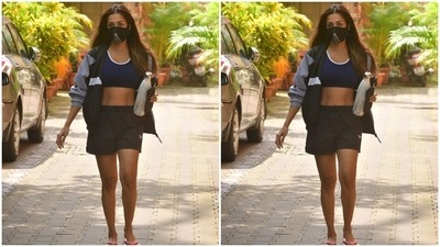 Malaika accessorised her gym attire with a blue and white jacket. All masked up, the actor left her wavy tresses open. (HT Photos/Varinder Chawla)