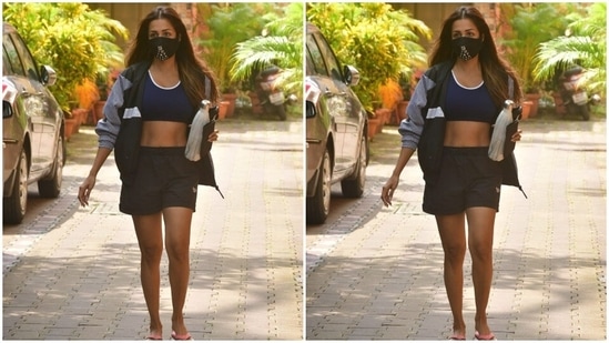 Malaika accessorised her gym attire with a blue and white jacket. All masked up, the actor left her wavy tresses open.(HT Photos/Varinder Chawla)