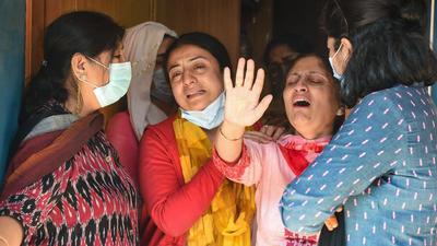 Relatives of pharmacist ML Bindroo mourn his death at his residence in Srinagar on Wednesday. Bindroo was shot dead Tuesday evening near his shop by militants in Jammu and Kashmir. (PTI) Relatives of pharmacist ML Bindroo mourn his death at his residence in Srinagar on Wednesday. Bindroo was shot dead Tuesday evening near his shop by militants in Jammu and Kashmir. (PTI)