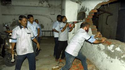 Workers demolish an illegally built wall at the parking bay in Supertech Emerald Court’s basement in Noida on Tuesday. (Sunil Ghosh/HT photo) Workers demolish an illegally built wall at the parking bay in Supertech Emerald Court’s basement in Noida on Tuesday. (Sunil Ghosh/HT photo)
